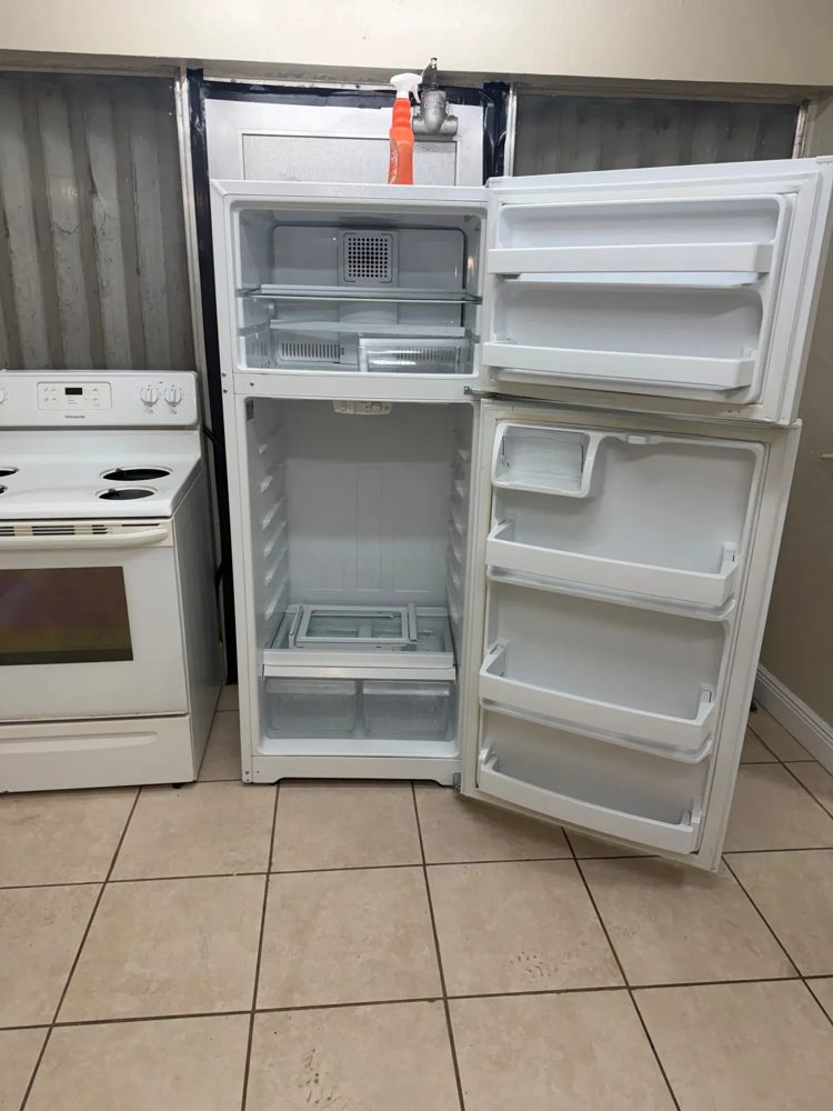 Refrigerator emptied and cleaned with doors open